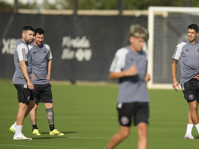 Inter Miami midfielder Jordi Alba, left, talks with forward Lionel Messi, as forward Luis Suarez, right, watches teammates practice during a training session for the MLS soccer team, Saturday, Jan. 13, 2024, in Fort Lauderdale, Fla. (AP Photo/Rebecca Blackwell)