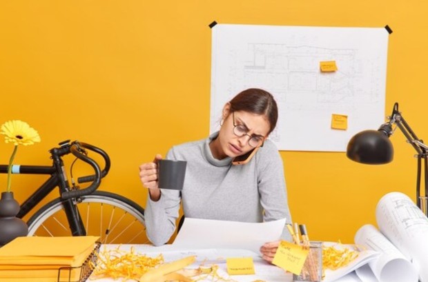 Menyibukkan diri/ foto: Freepik/ wayhomestudio Perempuan sedang sibuk mengerjakan pekerjaan kantor