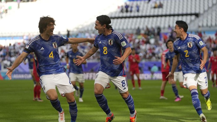 Japans Takumi Minamino, center, celebrates after scoring the opening goal during the Asian Cup Group D soccer match between Japan and Vietnam at Al Thumama Stadium in Doha, Qatar, Sunday, Jan. 14, 2024. (AP Photo/Thanassis Stavrakis)
