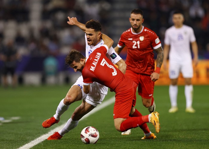 Soccer Football - AFC Asian Cup - Group B - Uzbekistan v Syria - Jassim bin Hamad Stadium, Al Rayyan, Qatar - January 13, 2024 Uzbekistans Oston Urunov in action with Syrias Mouaiad Al Ajaan REUTERS/Molly Darlington