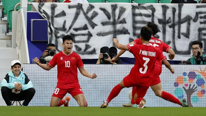 Vietnams forward #10 Pham Tuan Hai celebrates with teammates after scoring his teams second goal during the Qatar 2023 AFC Asian Cup Group D football match between Japan and Vietnam at the Al-Thumama Stadium in Doha on January 14, 2024. (Photo by KARIM JAAFAR / AFP)