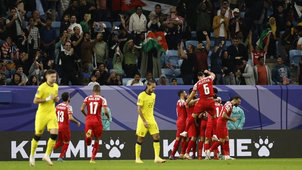 Soccer Football - AFC Asian Cup - Group E - Malaysia v Jordan - Al Janoub Stadium, Al Wakrah, Qatar - January 15, 2024  Jordan's Mousa Tamari celebrates scoring their second goal with teammates as Malaysia players look dejected REUTERS/Thaier Al-Sudani
