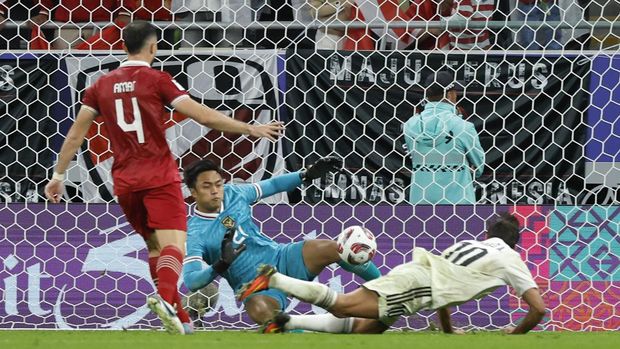 Indonesia's goalkeeper #21 Ernando Ari secures the goal past Iraq's forward #10 Mohanad Ali during the Qatar 2023 AFC Asian Cup Group D football match between Indonesia and Iraq at the Ahmad bin Ali Stadium in Al-Rayyan, west of Doha on January 15, 2024. (Photo by KARIM JAAFAR / AFP)