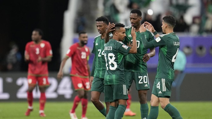 Saudi Arabias Abdulrahman Ghareeb, left, celebrates with teammates after scoring his sides first goal during the Asian Cup Group F soccer match between Saudi Arabia and Oman at Khalifa International Stadium in Doha, Qatar, Tuesday, Jan. 16, 2024. (AP Photo/Aijaz Rahi)