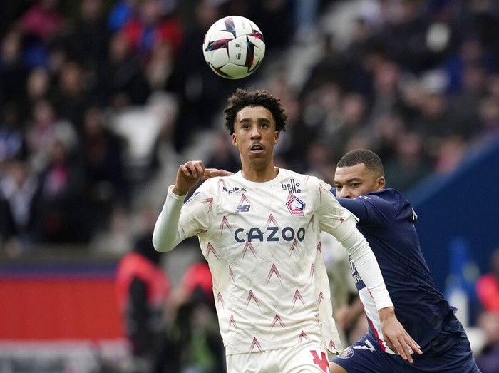 PSG's Kylian Mbappe, right, challenges for the ball with Lille's Leny Yoro during the French League One soccer match between Paris Saint-Germain and Lille at the Parc des Princes stadium, in Paris, France, Sunday, Feb. 19, 2023. (AP Photo/Christophe Ena)