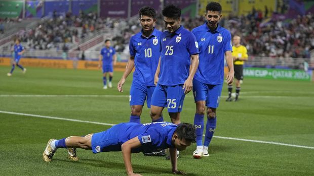 Thailand's Supachai Chaided, on ground, celebrates after scoring the opening goal during the Asian Cup Group F soccer match between Kyrgyzstan and Thailand at Abdullah Bin Khalifa Stadium in Doha, Qatar, Tuesday, Jan. 16, 2024. (AP Photo/Thanassis Stavrakis)