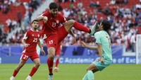 Begini momen tekel kungfu itu dilakukan Khalil Khamis ke Dai Wai Tsun, dalam laga yang pada akhirnya tidak membuahkan gol dalam skor 0-0 tersebut. Foto: AFP/KARIM JAAFAR