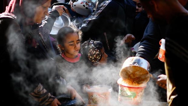 Palestinians wait to receive food cooked by a charity kitchen amid shortages of food supplies, amid the ongoing conflict between Israel and the Palestinian Islamist group Hamas, in Rafah in the southern Gaza Strip, January 16, 2024. REUTERS/Ibraheem Abu Mustafa