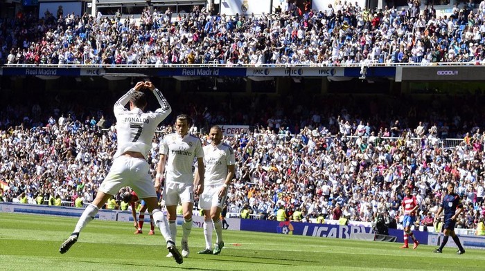 Real Madrid's Portuguese forward Cristiano Ronaldo (L) celebrates a goal during the Spanish league football match Real Madrid CF vs Granada FC at the Santiago Bernabeu stadium in Madrid on April 5, 2015.   AFP PHOTO/ GERARD JULIEN (Photo by GERARD JULIEN / AFP)