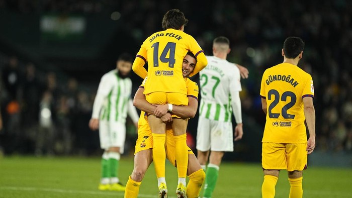 Barcelonas Joao Felix celebrates with Barcelonas Ferran Torres after scoring his sides third goal during a Spanish La Liga soccer match between Betis and Barcelona at the Benito Villamarin stadium in Seville, Spain, Sunday, Jan. 21, 2024. (AP Photo/Jose Breton)