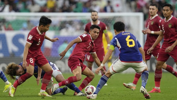 Indonesias Marselino Ferdinan, centre, battles for the ball with Japans Wataru Endo during the Asian Cup Group D soccer match between Japan and Indonesia at Al Thumama in Doha, Qatar, Wednesday, Jan. 24, 2024. (AP Photo/Thanassis Stavrakis)