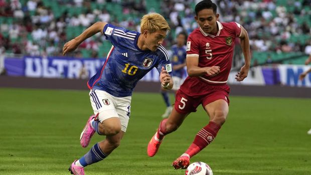 Japan's Ritsu Doan runs with the ball next to Indonesia's Rizky Ridh Ramadhani during the Asian Cup Group D soccer match between Japan and Indonesia at Al Thumama in Doha, Qatar, Wednesday, Jan. 24, 2024. (AP Photo/Thanassis Stavrakis)