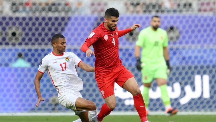 DOHA, QATAR - JANUARY 25: Sayed Baqer of Bahrain is challenged by Salem Al-Ajalin of Jordan during the AFC Asian Cup Group E match between Jordan and Bahrain at Khalifa International Stadium on January 25, 2024 in Doha, Qatar. (Photo by Adam Nurkiewicz/Getty Images)