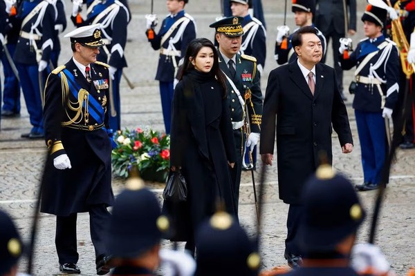 Presiden Korsel Yoon Suk Yeol bersama istrinya, Kim Keon Hee South Koreas President Yoon Suk Yeol and his wife Kim Keon Hee walk during a ceremony in Amsterdam, Netherlands December 12, 2023. REUTERS/Piroschka van de Wouw/File Photo Acquire Licensing Rights, opens new tab