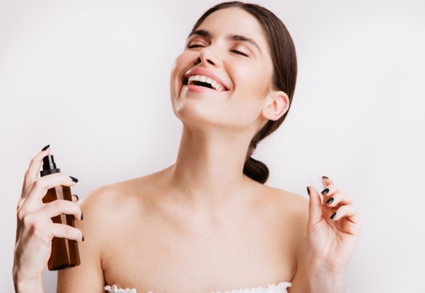 Perempuan sedang memakai parfum