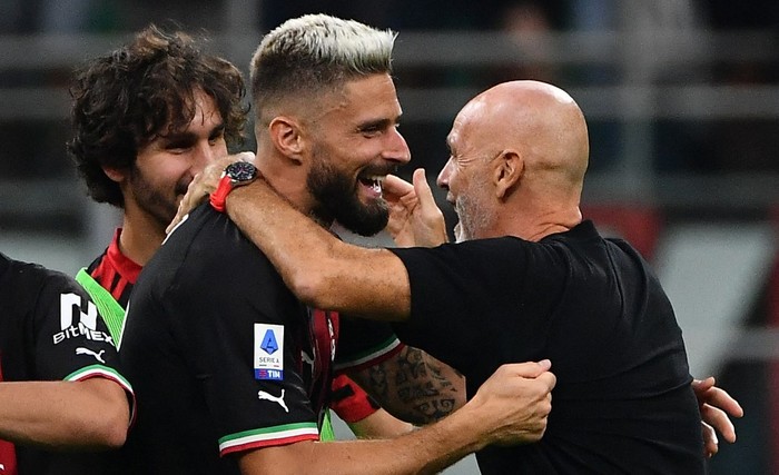 AC Milans French forward Olivier Giroud (L) and AC Milans Italian coach Stefano Pioli (R) celebrate the victory after the Italian Serie A football match between AC Milan and Inter Milan at the San Siro stadium in Milan on September 3, 2022. (Photo by Isabella BONOTTO / AFP)