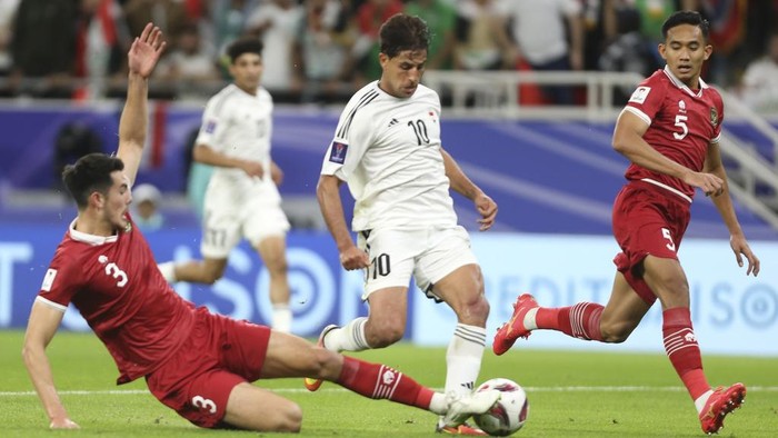 Indonesias Elkan Baggot tackles Iraqs Mohanad Ali Kadhim during the Asian Cup Group D soccer match between Indonesia and Iraq at Ahmad Bin Ali Stadium in Al Rayyan, Qatar, Monday, Jan. 15, 2024. (AP Photo/Hussein Sayed)