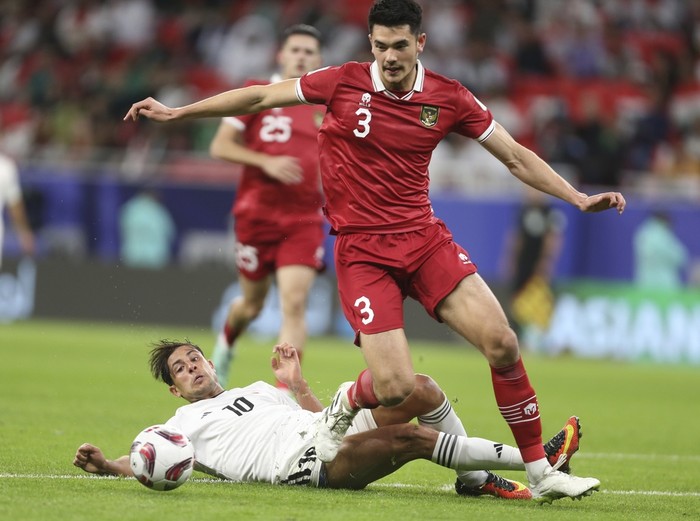 Indonesias Elkan Baggott dribbles Iraqs Mohanad Ali Kadhim during the Asian Cup Group D soccer match between Indonesia and Iraq at Ahmad Bin Ali Stadium in Al Rayyan, Qatar, Monday, Jan. 15, 2024. (AP Photo/Hussein Sayed)