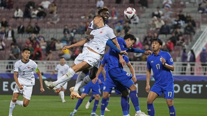 Kyrgyzstan's Akmatov Aizar, center front, and Joel Kojo, rear, fights for the ball with Thailand's Weerathep Pomphun, second right, during the Asian Cup Group F soccer match between Kyrgyzstan and Thailand at Abdullah Bin Khalifa Stadium in Doha, Qatar, Tuesday, Jan. 16, 2024. (AP Photo/Thanassis Stavrakis)