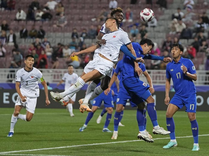 Kyrgyzstan's Akmatov Aizar, center front, and Joel Kojo, rear, fights for the ball with Thailand's Weerathep Pomphun, second right, during the Asian Cup Group F soccer match between Kyrgyzstan and Thailand at Abdullah Bin Khalifa Stadium in Doha, Qatar, Tuesday, Jan. 16, 2024. (AP Photo/Thanassis Stavrakis)