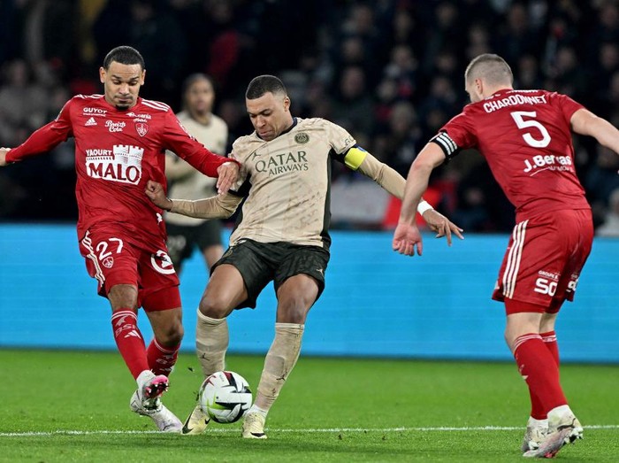 Paris Saint-Germains French forward #07 Kylian Mbappe (C) vies with Brests French defender #27 Kenny Lala (L) during the French L1 football match between Paris Saint-Germain (PSG) and Stade Brestois 29 (Brest) at The Parc des Princes Stadium in Paris on January 28, 2024. (Photo by Miguel MEDINA / AFP)
