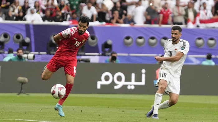 Iraqs Aymen Hussein, right, scores his sides second goal during the Asian Cup Round of 16 soccer match between Iraq and Jordan, at Khalifa International Stadium in Doha, Qatar, Monday, Jan. 29, 2024. (AP Photo/Thanassis Stavrakis)