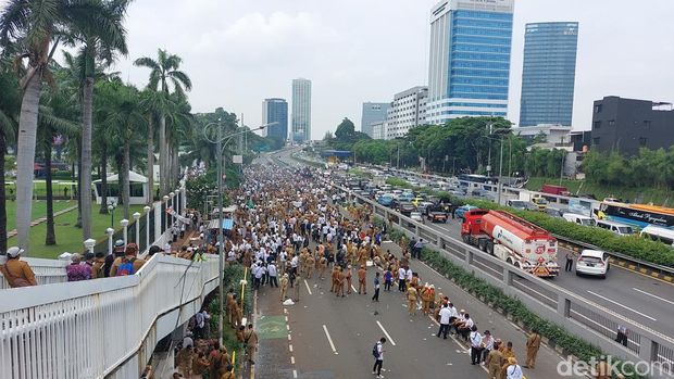 Sejumlah kendaraan di jalan tol terhambat karena massa memblokade jalan tol.