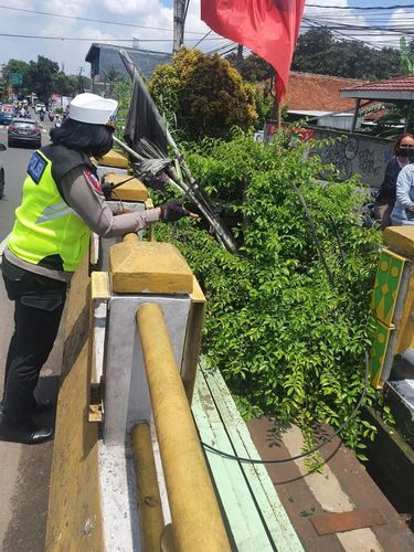 Anggota Satlantas Polres Metro Depok menerima laporan dari masyarakat terkait kabel menjuntai di dekat jembatan Ratujaya untuk memastikan lalu lintas aman. (dok IG @lantasrestrodepok)