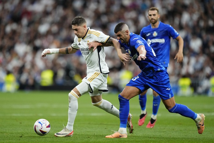 Getafes Stefan Mitrovic, right, challenges Real Madrids Federico Valverde during Spanish La Liga soccer match between Real Madrid and Getafe at the Santiago Bernabeu stadium in Madrid, Spain, Saturday, Sept. 2, 2023. (AP Photo/Jose Breton)