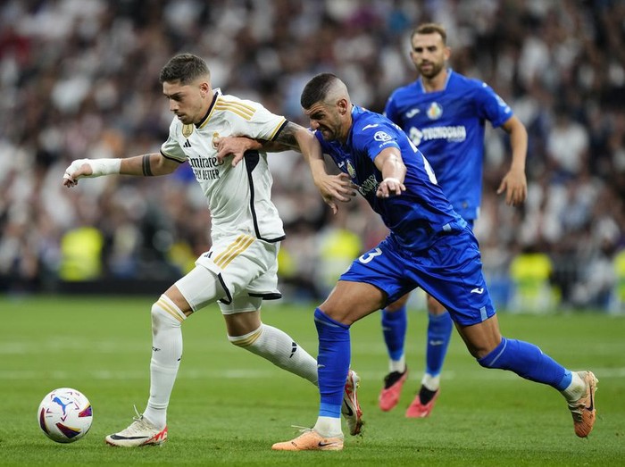 Getafe's Stefan Mitrovic, right, challenges Real Madrid's Federico Valverde during Spanish La Liga soccer match between Real Madrid and Getafe at the Santiago Bernabeu stadium in Madrid, Spain, Saturday, Sept. 2, 2023. (AP Photo/Jose Breton)