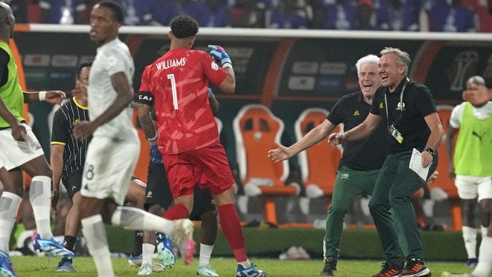 South Africa's head coach Hugo Broos, second right, rushes to greet South Africa's goalkeeper Ronwen Williams as they celebrate after winning a penalty shootout at the end of the African Cup of Nations quarter final soccer match between Cape Verde and South Africa, at the Charles Konan Banny stadium in Yamoussoukro, Ivory Coast, Saturday, Feb. 3, 2024. South Africa keeper Ronwen Williams saved four out of five penalties in the shootout. (AP Photo/Themba Hadebe)