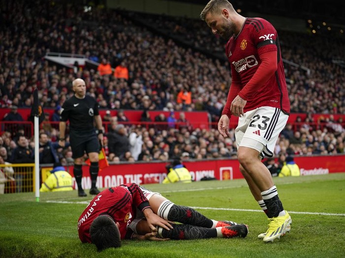 Manchester United's Lisandro Martinez lies on the pitch after an injury during the English Premier League soccer match between Manchester United and West Ham United at the Old Trafford stadium in Manchester, England, Sunday, Feb. 4, 2024. (AP Photo/Dave Thompson)