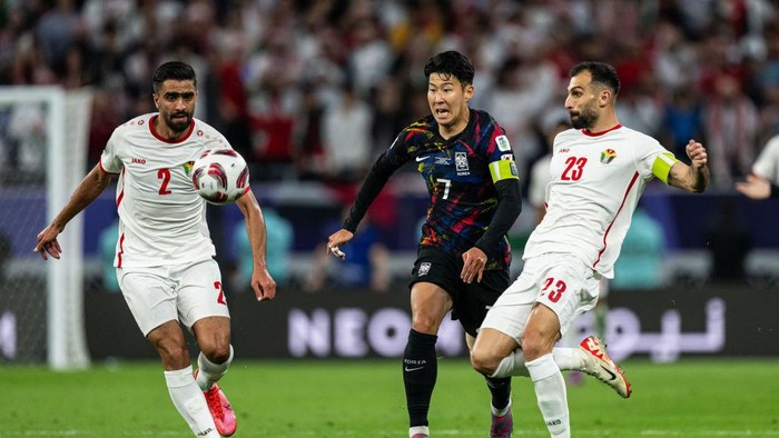 DOHA, QATAR - FEBRUARY 06: Son Heung-min of South Korea is tackled by Mohammad Abu Hasheesh (L) and Ihsan Haddad (R) of Jordan during the AFC Asian Cup semi final match between Jordan and South Korea at Ahmad Bin Ali Stadium on February 06, 2024 in Doha, Qatar. (Photo by Markus Gilliar - GES Sportfoto/Getty Images)