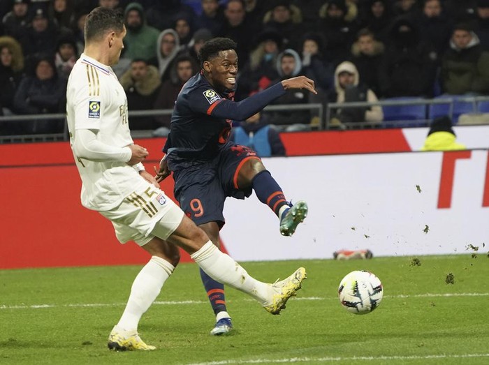 Lille's Jonathan David, right, and Lille's Gabriel Gudmundsson challenge for the ball during the French League One soccer match between Lyon and Lille at the Groupama stadium, outside Lyon, France, Sunday, Nov. 26, 2023. (AP Photo/Laurent Cipriani)