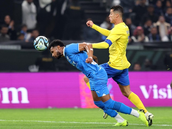 Soccer Football - Friendly - Al Nassr v Al Hilal - Kingdom Arena, Riyadh, Saudi Arabia - February 8, 2024 Al Hilal's Ali Al-Bulayhi in action with Al Nassr's Cristiano Ronaldo REUTERS/Ahmed Yosri