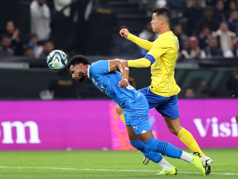 Soccer Football - Friendly - Al Nassr v Al Hilal - Kingdom Arena, Riyadh, Saudi Arabia - February 8, 2024 Al Hilal's Ali Al-Bulayhi in action with Al Nassr's Cristiano Ronaldo REUTERS/Ahmed Yosri