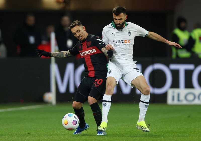 Soccer Football - Bundesliga - Bayer Leverkusen v Borussia Moenchengladbach - BayArena, Leverkusen, Germany - January 27, 2024 Bayer Leverkusen's Alejandro Grimaldo in action with Borussia Moenchengladbach's Franck Honorat REUTERS/Thilo Schmuelgen DFL REGULATIONS PROHIBIT ANY USE OF PHOTOGRAPHS AS IMAGE SEQUENCES AND/OR QUASI-VIDEO.