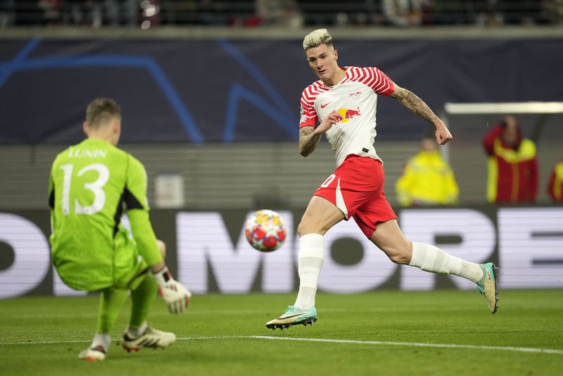 Leipzig's Benjamin Sesko misses to score against Real Madrid's goalkeeper Andriy Lunin during the Champions League round of 16 first leg soccer match between RB Leipzig and Real Madrid at the Red Bull arena stadium in Leipzig, Germany, Tuesday, Feb. 13, 2024. (AP Photo/Matthias Schrader)