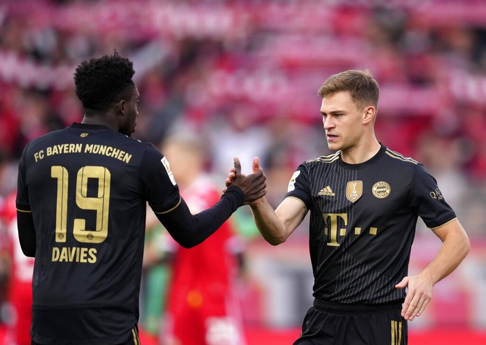 Bayerns Joshua Kimmich, right, shakes hands with Bayerns Alphonso Davies prior to the German Bundesliga soccer match between 1. FC Union Berlin and FC Bayern Munich in Berlin, Germany, Saturday, Oct. 30, 2021. (AP Photo/Michael Sohn)