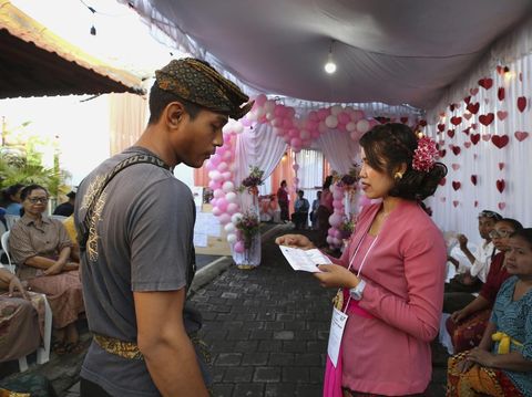 A man waits for his turn to vote at a Valentine's Day themed polling station during the presidential and legislative election in Denpasar, Bali, Indonesia, Wednesday, Feb. 14, 2024. (AP Photo/Firdia Lisnawati)