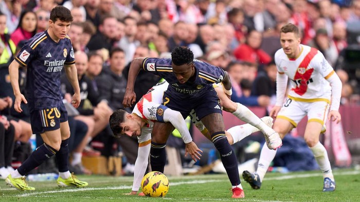 MADRID, SPAIN - FEBRUARY 18: Vinicius Junior of Real Madrid battles for possession with Oscar Valentin Martin of Rayo Vallecano during the LaLiga EA Sports match between Rayo Vallecano and Real Madrid CF at Estadio de Vallecas on February 18, 2024 in Madrid, Spain. (Photo by Angel Martinez/Getty Images)