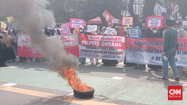 Massa aksi Gerakan Masyarakat Sipil Selamatkan Demokrasi Indonesia mengibarkan bendera kuning dan membakar ban di kawasan depan kantor Komisi Pemilihan Umum (KPU) di Jalan Imam Bonjol, Jakarta Pusat, Senin (19/2).