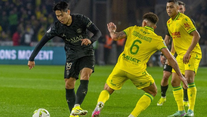 PSGs Lee Kang-in, left, duels for the ball with Nantes Douglas Augusto during the French League One soccer match between Nantes and Paris Saint-Germain at the Stade de la Beaujoire in Nantes, France, Saturday, Feb. 17, 2024. (AP Photo/Mathieu Pattier)