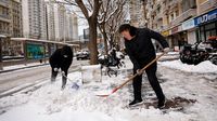 Berjibaku Bersihkan Salju Tebal di Jalanan Beijing