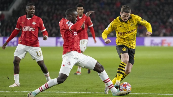 Dortmunds Marcel Sabitzer, right, tussles for the ball with PSVs Jordan Teze during the Champions League round of 16 first leg soccer match between PSV Eindhoven and Borussia Dortmund at Philips stadium in Eindhoven, Netherlands, Tuesday, Feb. 20, 2024. (AP Photo/Peter Dejong)