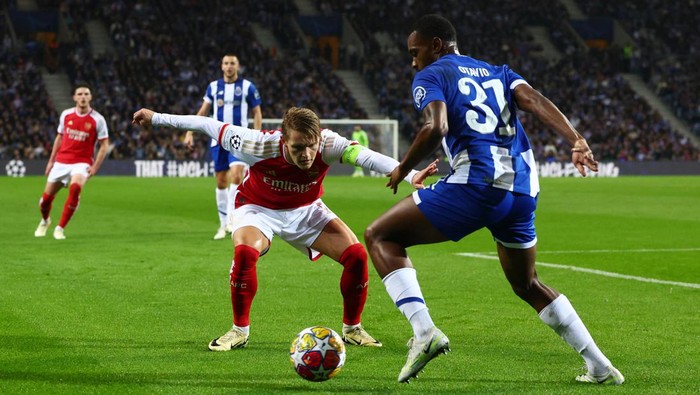 Soccer Football - Champions League - Round of 16 - First Leg - FC Porto v Arsenal - Estadio do Dragao, Porto, Portugal - February 21, 2024 Arsenals Martin Odegaard in action with FC Portos Otavio REUTERS/Pedro Nunes