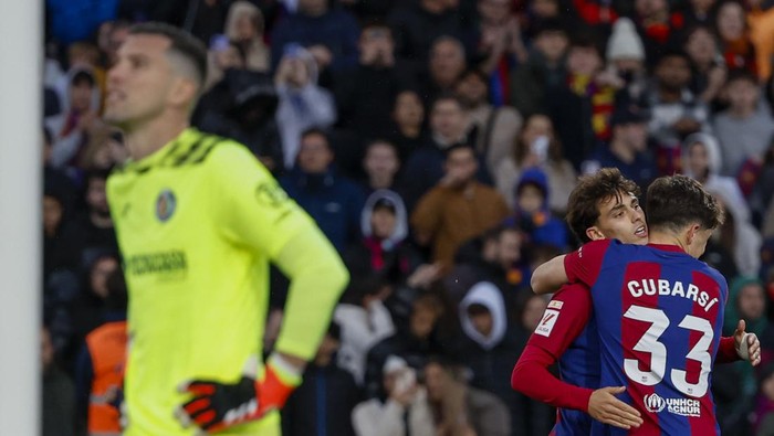 Barcelonas Joao Felix celebrates with Barcelonas Pau Cubarsi after scoring his sides second goal during a Spanish La Liga soccer match between Barcelona and Getafe at the Olimpic Lluis Companys stadium in Barcelona, Spain, Saturday, Feb. 24, 2024. (AP Photo/Joan Monfort)