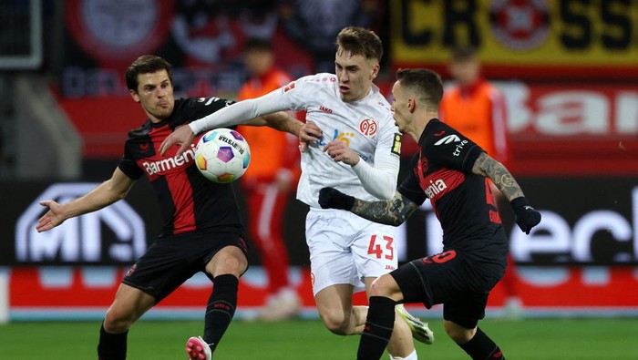 Soccer Football - Bundesliga - Bayer Leverkusen v 1.FSV Mainz 05 - BayArena, Leverkusen, Germany - February 23, 2024 1.FSV Mainz 05s Brajan Gruda in action with Bayer Leverkusens Alejandro Grimaldo and Jonas Hofmann REUTERS/Thilo Schmuelgen DFL REGULATIONS PROHIBIT ANY USE OF PHOTOGRAPHS AS IMAGE SEQUENCES AND/OR QUASI-VIDEO.