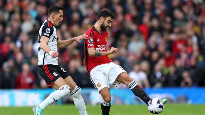 MANCHESTER, ENGLAND - FEBRUARY 24: Bruno Fernandes of Manchester United is challenged by Sasa Lukic of Fulham during the Premier League match between Manchester United and Fulham FC at Old Trafford on February 24, 2024 in Manchester, England. (Photo by Clive Brunskill/Getty Images)