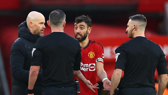 Soccer Football - Premier League - Manchester United v Fulham - Old Trafford, Manchester, Britain - February 24, 2024 Manchester Uniteds Bruno Fernandes and manager Erik ten Hag with referee Michael Oliver after the match REUTERS/Carl Recine NO USE WITH UNAUTHORIZED AUDIO, VIDEO, DATA, FIXTURE LISTS, CLUB/LEAGUE LOGOS OR LIVE SERVICES. ONLINE IN-MATCH USE LIMITED TO 45 IMAGES, NO VIDEO EMULATION. NO USE IN BETTING, GAMES OR SINGLE CLUB/LEAGUE/PLAYER PUBLICATIONS.